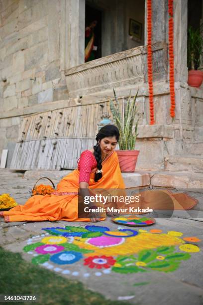 beautiful indian woman in a sari making rangoli - preparation of gudi padwa festival stock pictures, royalty-free photos & images