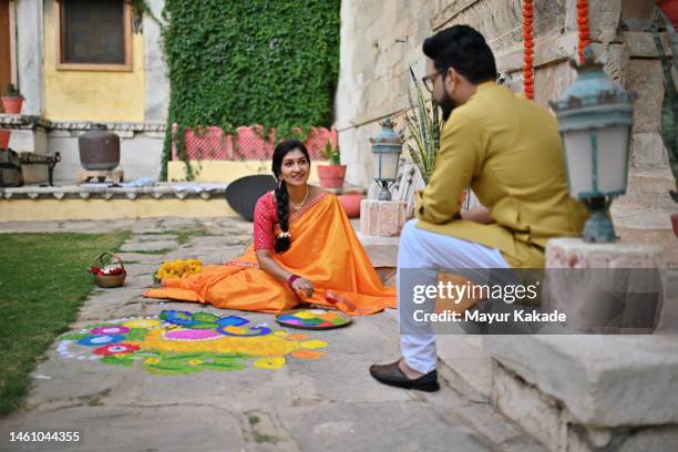 indian woman making rangoli with her husband - preparation of gudi padwa festival stock pictures, royalty-free photos & images