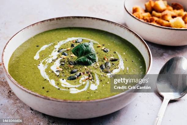 green vegetables soup with cream and croutons - cris cantón photography stock-fotos und bilder