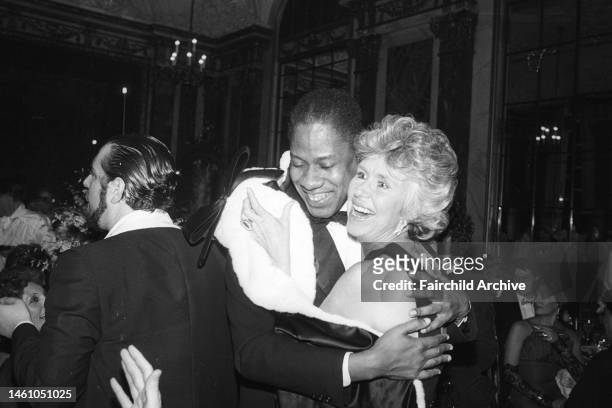 Andre Leon Talley hugging a fellow guest at the Fendi sisters Carvnevale dinner-dance to celebrate the launch of their signature fragrance, patterned...