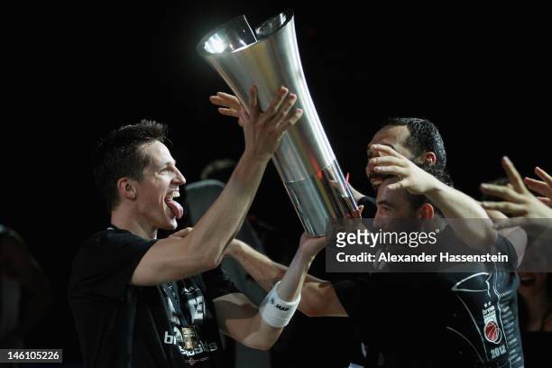 Casey Jacobsen of Bamberg presents the Champions Trophy to his team mates Predrag Surup and Karsten Tadda after winning game 3 of the Beko BBL finals...