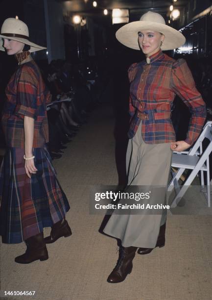 Model wearing plaid blouse with khaki skirt and a wide-brimmed hat and lace-up boots from Ralph Lauren RTW spring/summer 1984 collection on the runway