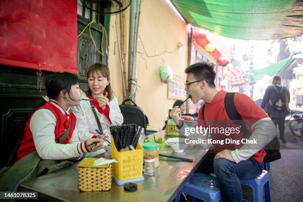 familia asiática china disfrutando de comida callejera en hanoi vietnam - vietnam teen fotografías e imágenes de stock