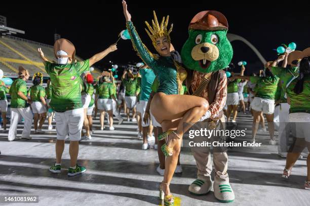 Aline Mineiro, muse of Mocidade Independente de Padre Miguel, poses with Castorzinho, the mascot of Mocidade, while samba dancers rehearse at the...