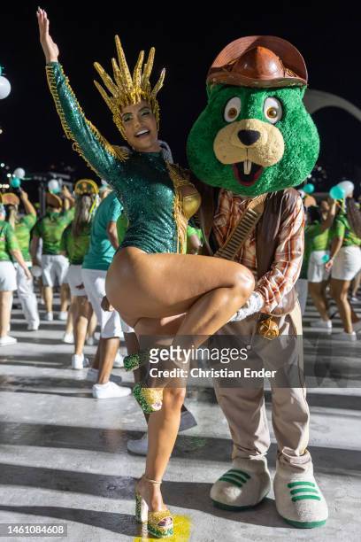 Aline Mineiro, muse of Mocidade Independente de Padre Miguel, poses with Castorzinho, the mascot of Mocidade, while samba dancers rehearse at the...
