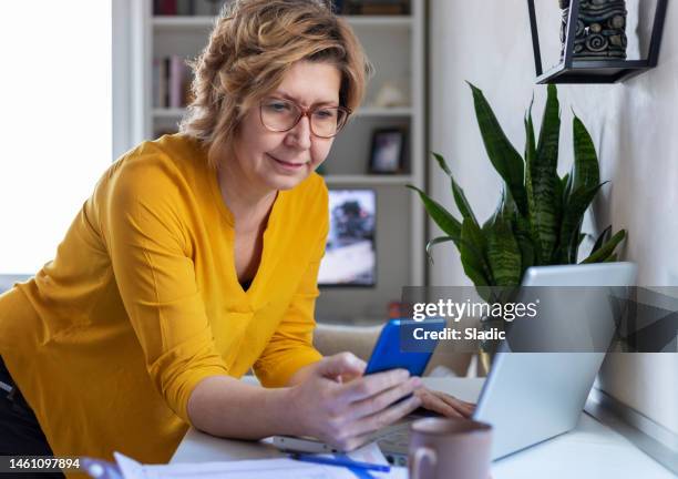 concentrated mature woman calculating finance - coping stock pictures, royalty-free photos & images