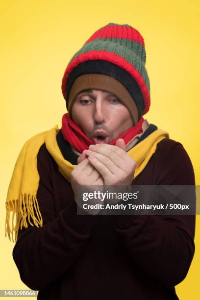 shameful african american pulling a green winter hat over his face he - beef stockfoto's en -beelden