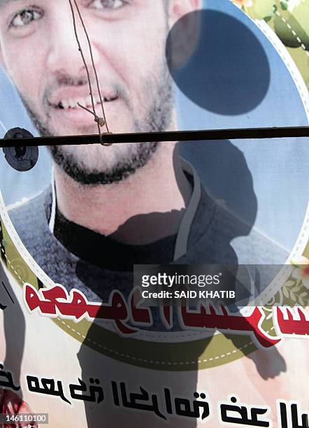 The shadow of a Palestinian youth playing football is silhouetted against a banner forming part of a protest tent in solidarity with Palestinian...