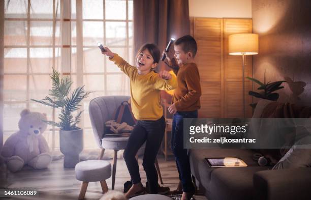 happy young girl playing with her brother during playtime - girl on couch with dog stock pictures, royalty-free photos & images