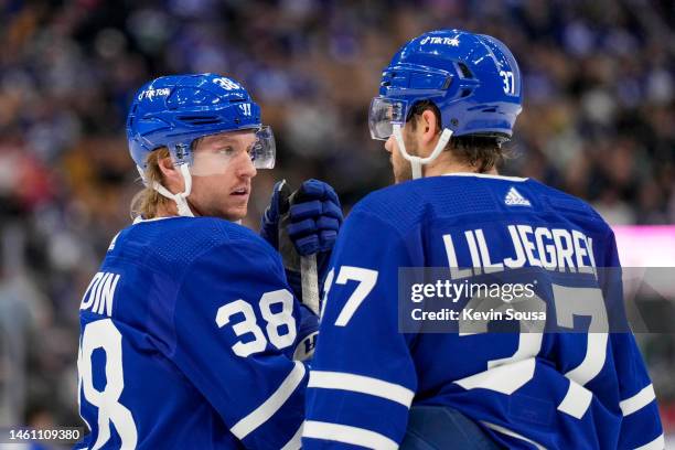 Rasmus Sandin of the Toronto Maple Leafs talks to teammate Timothy Liljegren during the third period against the Washington Capitals at the...