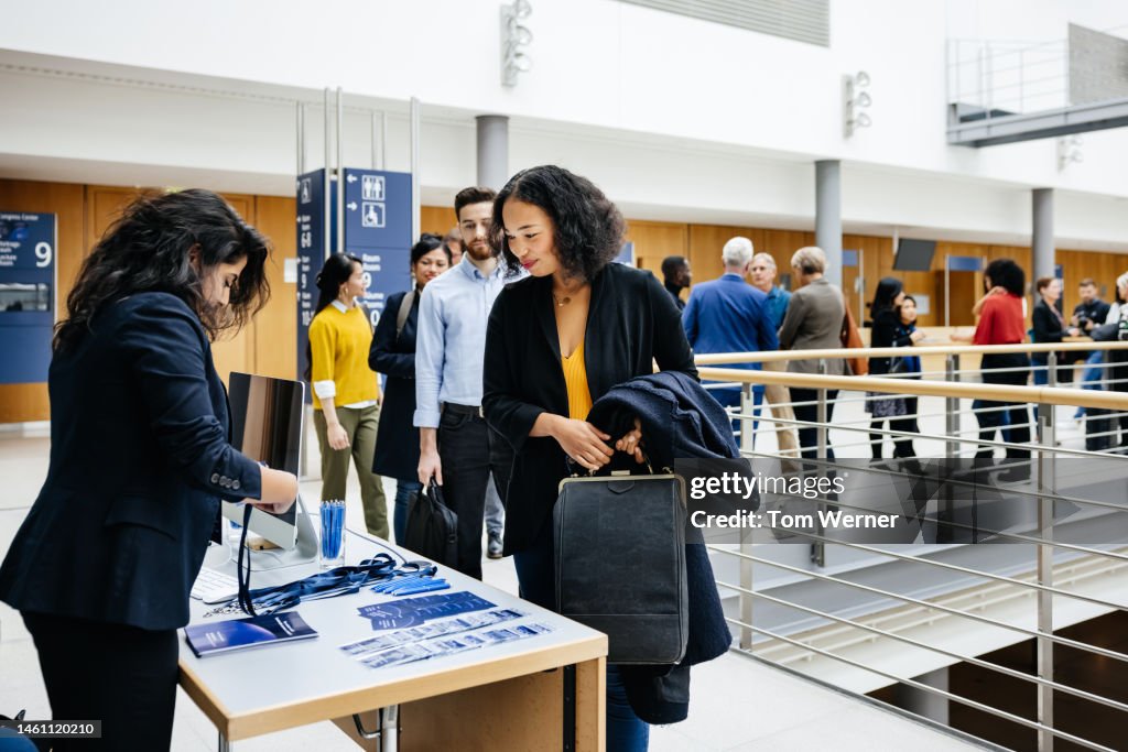 Attendees signing in at Business Conference Registration Desk