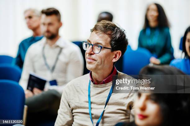 business conference attendee listening during presentation - educational event stock pictures, royalty-free photos & images