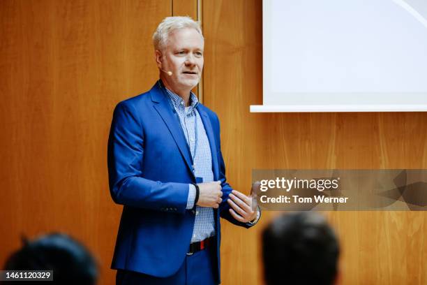 speaker at business conference giving presentation - man standing talking stockfoto's en -beelden