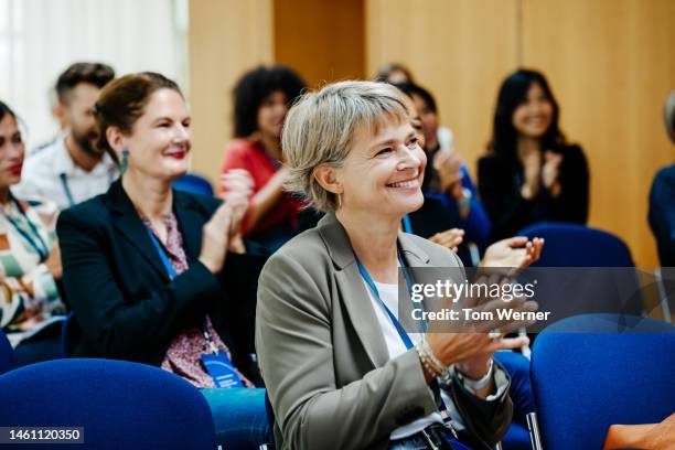 business conference attendees applauding during presentation - attending photos et images de collection