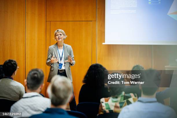 presentation being given by businesswoman at conference - congreszaal stockfoto's en -beelden