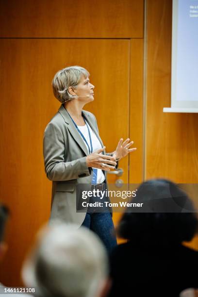 businesswoman giving presentation to convention attendees - candidate experience stock pictures, royalty-free photos & images