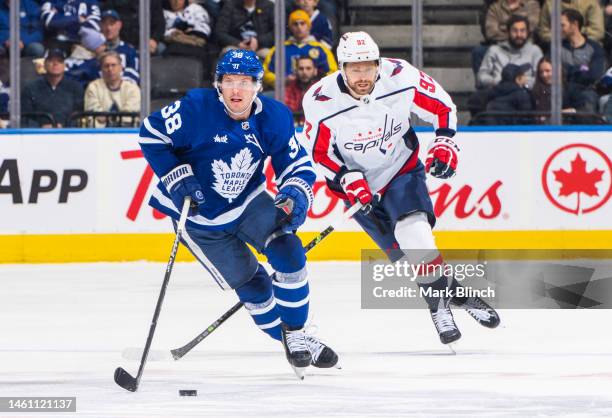 Rasmus Sandin of the Toronto Maple Leafs skates against Evgeny Kuznetsov of the Washington Capitals during the first period at the Scotiabank Arena...