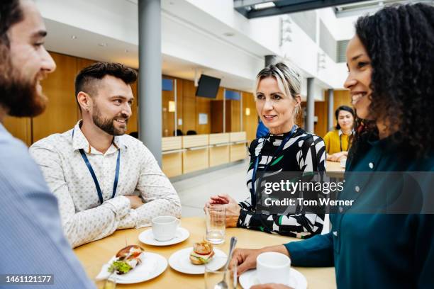 group of people eating lunch together at business conference - mittagessen stock-fotos und bilder