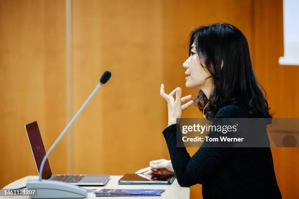 businesswoman talking into microphone - woman microphone stock pictures, royalty-free photos & images