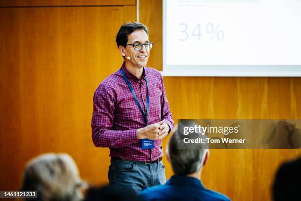 businessman wearing headset while giving presentation - 50 60 jahre brille stock-fotos und bilder