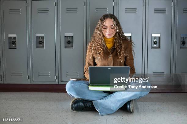 female student in high school hallway using laptop - college girl stock pictures, royalty-free photos & images