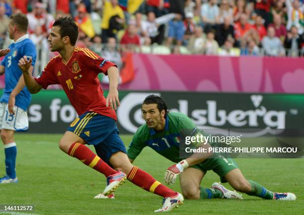 Spanish midfielder Cesc Fabregas scores against Italian goalkeeper Gianluigi Buffon during the Euro 2012 championships football match Spain vs Italy...