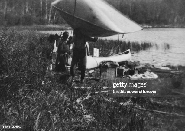 gruppo di spedizione di rilevamento che trasporta canoe e attrezzature dal fiume sturgeon-weir nel saskatchewan, canada - 1919 - porter foto e immagini stock