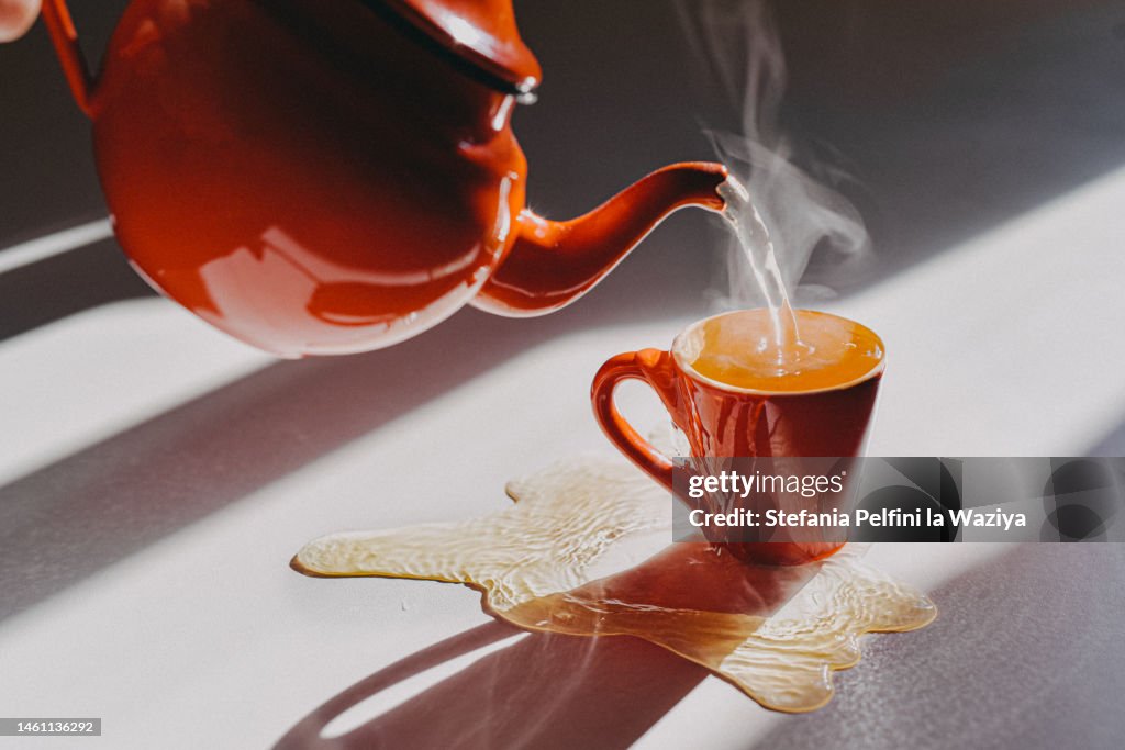 Hot Tea Spilling out From Small Cup