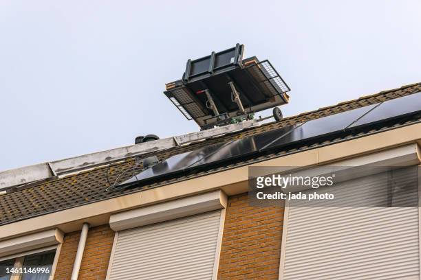 mobile platform on a ladder when installing solar panels on the roof of a house - lift roof stock-fotos und bilder