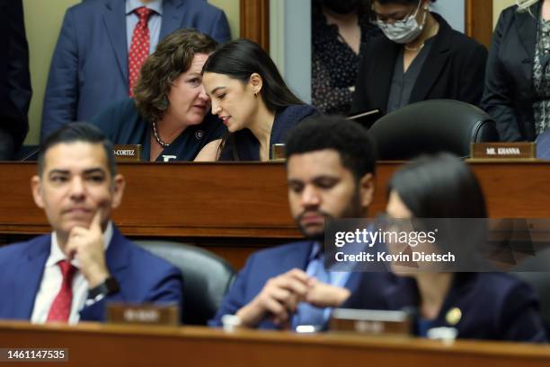 Rep. Katie Porter talks to Rep. Alexandria Ocasio-Cortez during a meeting of the House Oversight and Reform Committee in the Rayburn House Office...