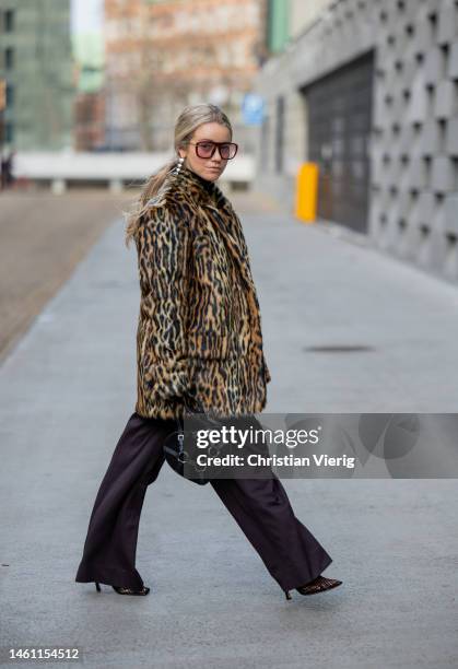 Joicy Muniz wears leopard print coat Stand Studio, black bodysuit Mugler, wide leg pants Attire, bag Maison Alaia, earrings Trine Tuxen, shoes...