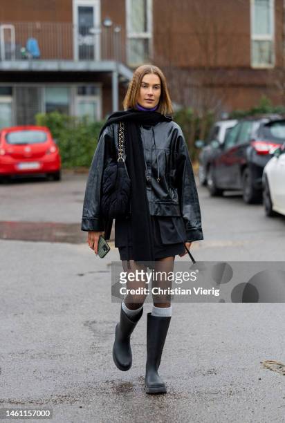 Vera van Erp wears black leather jacket, tights, knee high socks, rain boots wears outside Aeron during the Copenhagen Fashion Week Autumn/Winter...
