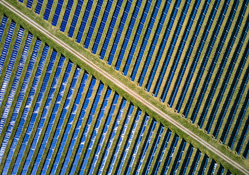 Aerial view of country road amidst photovoltaic panels