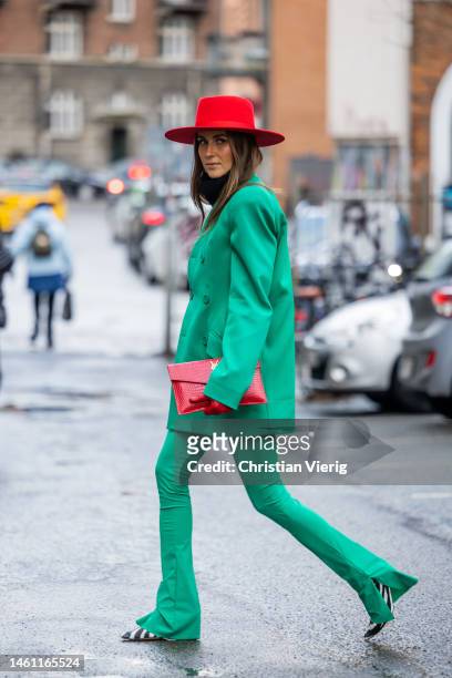 Nina Sandbech wears red hat, gloves, clutch, strong shoulder line blazer in green, pants outside Rabens Saloner during the Copenhagen Fashion Week...