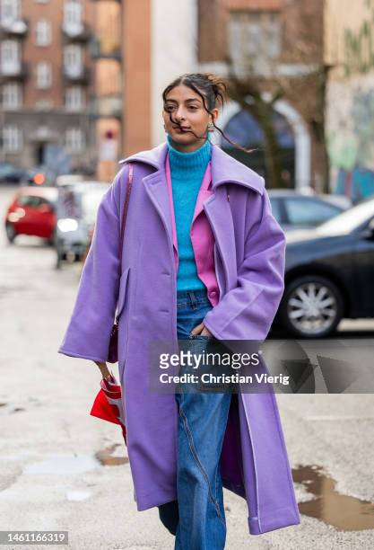 Melanie Darmon wears lavender colored wool coat, turquoise turtleneck, denim jeans, pink pointed heels outside Rabens Saloner during the Copenhagen...