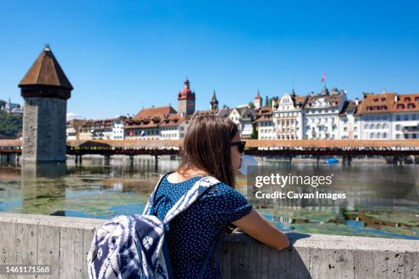 teen girl takes in view of lucerne switzerland while blowing a bubble - luzern stock-fotos und bilder