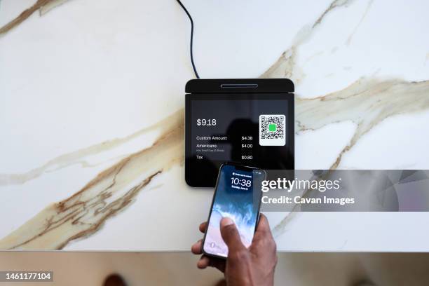 cropped hand of customer taping smart phone on marble counter - contactless stock pictures, royalty-free photos & images