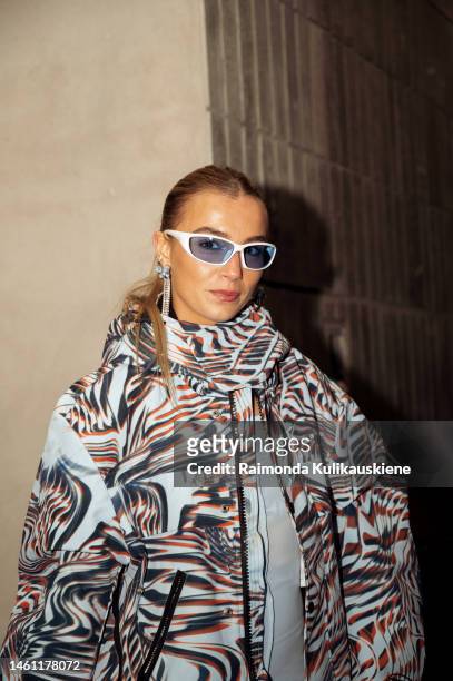 Guest wears blue pants, a light blue silk dress, ligth blue jacket with pattern, blue bag, silver boots and blue sunglasses outside Remain during the...