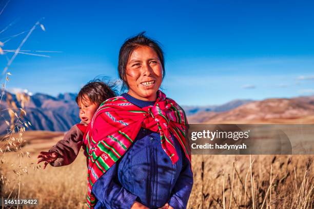 peruvian woman carrying her baby on the back near cuzco - peruvian culture stock pictures, royalty-free photos & images