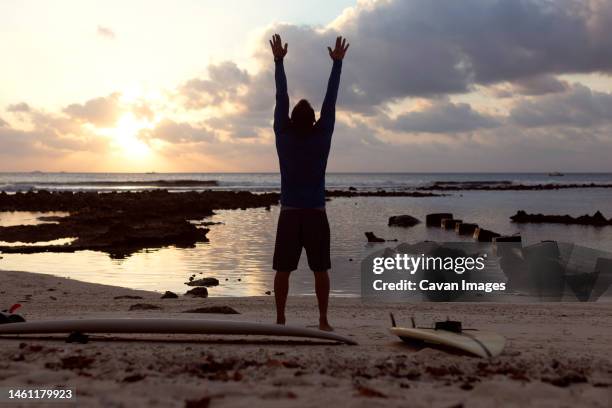 male surfer practising yoga at the beach - thulusdhoo stock pictures, royalty-free photos & images