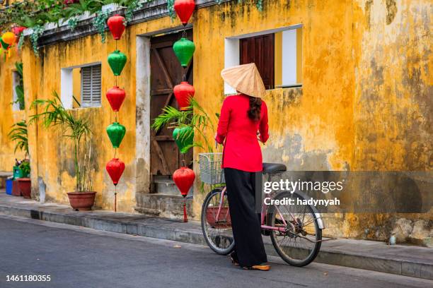 vietnamese woman with a bicycle, old town in hoi an city, vietnam - asian style conical hat stockfoto's en -beelden