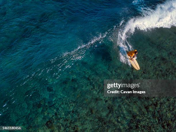 aerial view of surfer on a wave - denpasar stock pictures, royalty-free photos & images