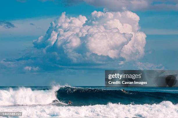 male surfer on the wave under clouds - thulusdhoo stock pictures, royalty-free photos & images