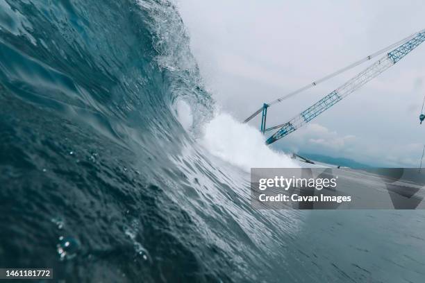 low angle view of crane at ocean coast - tsunami stock-fotos und bilder