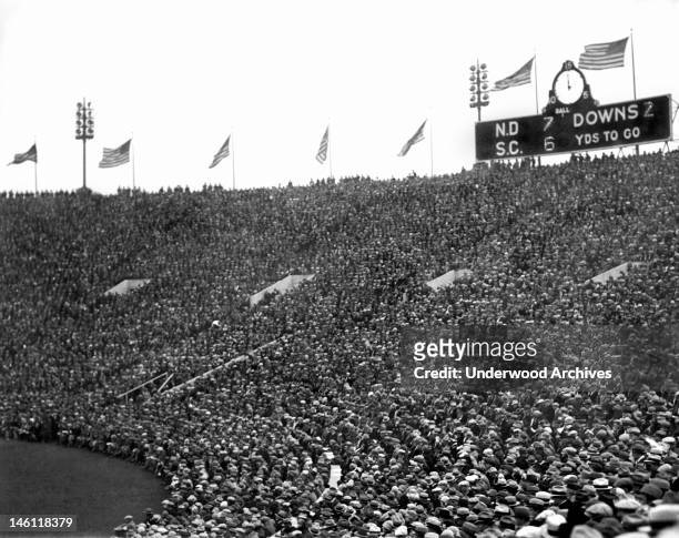 The scoreboard and crowd at halftime during the Notre Dame-USC football game at Soldiers Field, Chicago, Illinois, November 26, 1927. The Fighting...