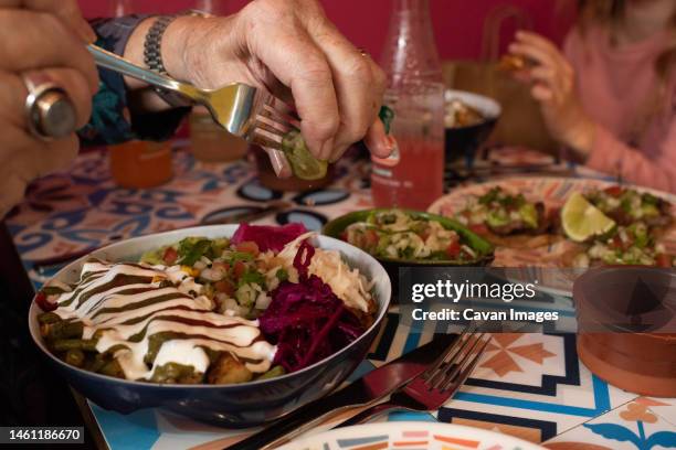 person squeezing lime on authentic mexican food in a restaurant - nachos guacamole stock pictures, royalty-free photos & images