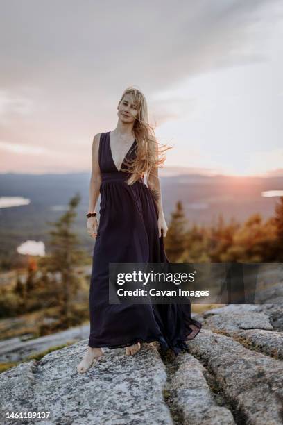 beautiful blonde woman barefoot in long dress with tattoo at sunset - sunset tattoo designs stock pictures, royalty-free photos & images