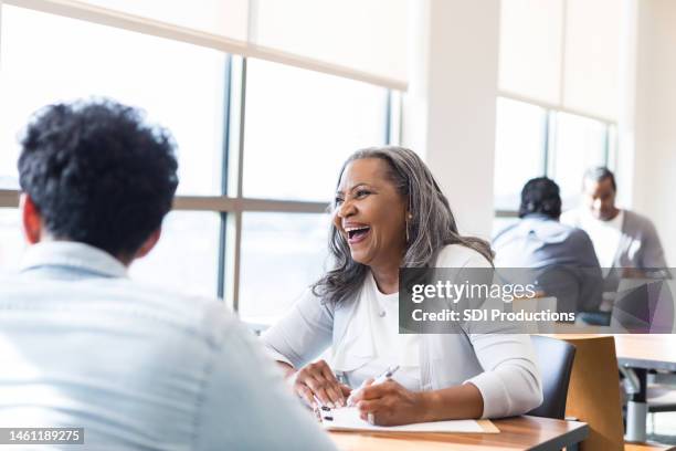 college admissions counselor smiles and laughs with prospective students - job fair stock pictures, royalty-free photos & images