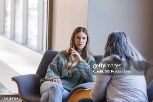 una giovane donna adulta seria condivide le lotte con il terapeuta femminile - psicoterapeuta foto e immagini stock