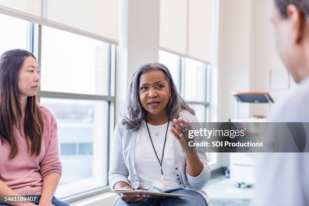 in group therapy, woman listens as counselor gives man advice - inclusive leadership stock pictures, royalty-free photos & images